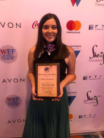 Beatriz Calvo Garro, illustrator of the stories of the International Literary Contest "My World My Way" holds in her hands the award received at the Women Economic Forum 2019 in Cartagena, Colombia.
