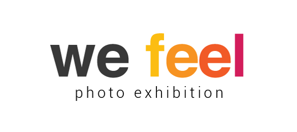 Logo of the photographic exhibition We Feel. The letters of “We” in black color while the letters of the word “Feel” change, from left to right, from yellow to orange and purple.