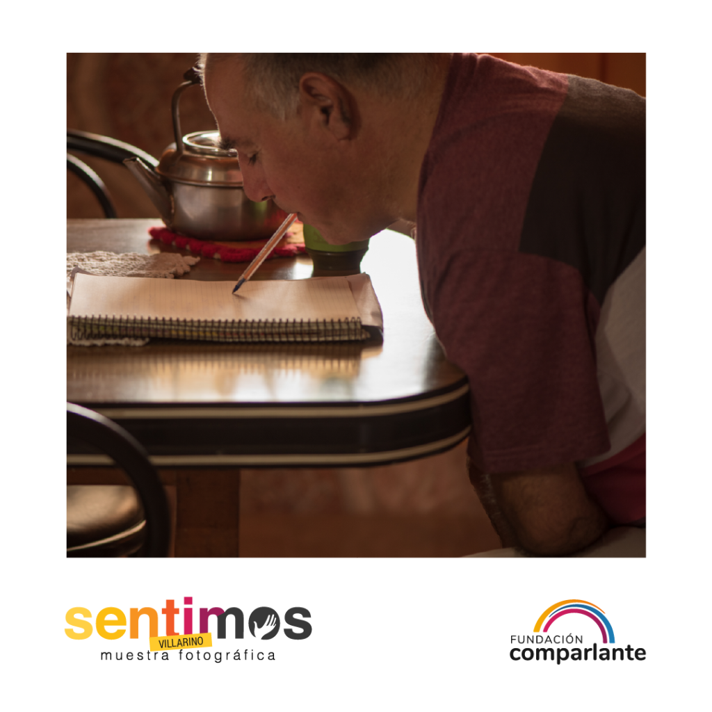 Fotografía de Horacio, Promotor de derechos, escribiendo en una hoja con una lapicera que sostiene con su boca. Debajo se ubican el logotipo de Sentimos y de Fundación Comparlante.
