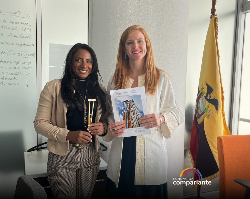 Fotografía donde están Lorena Julio, Presidente de Fundación Comparlante y Jeimy Hernandez, Subsecretaria de Discapacidades, sonriendo a cámara. Lorena sostiene y muestra a cámara la Carta de Compromiso firmada.