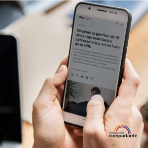 Fotografía de una persona sosteniendo un celular que en pantalla muestra la noticia de Filo News titulada “Un joven argentino de 18 años representará a Latinoamérica en un Foro de la ONU. Gerónimo Bukosky se prepara para representar a América Latina en el Foro de la Juventud de ONU. El joven planea abordar la falta de acceso a la educación y el empleo, especialmente para aquellos con discapacidad.