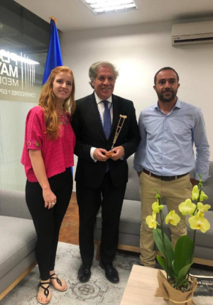 Lorena Julio, President of Fundación Comparlante, Luis Almagro, Secretary General of the Organization of American States and Andrés Julio, artist in charge of the Accessible Art exhibition, pose for a photography while Luis Almagro holds in his hands the flagship work of the exhibition titled “Crutches”.